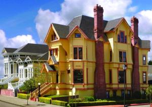 a yellow house with two chimneys on a street at Carter House Inns in Eureka