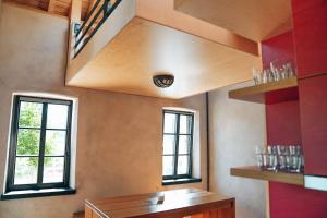 eine Küche mit zwei Fenstern und einem Holztisch in der Unterkunft Den Alen Arbed's Büro in Kayl