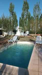 a swimming pool with two chairs and a table at Apartamento Cerrito in San Rafael