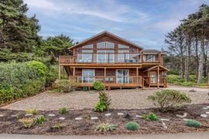 a large wooden house with a large deck at Miss Olena in Seal Rock