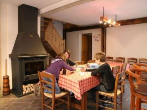 a group of people sitting at a table in front of a fireplace at Gîte spacieux, confort moderne, 8 pers, terrasse privative, animaux admis, WiFi - FR-1-589-227 in Vagney +25 photos