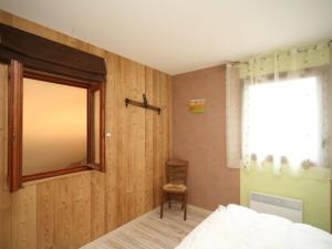 a bedroom with a bed and a window and a chair at Gîte Vagney, 5 pièces, 8 personnes - FR-1-589-227 in Vagney