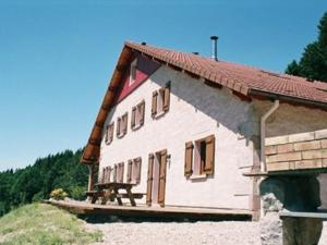 ein Haus mit einer Bank an der Seite in der Unterkunft Gîte Vagney, 5 pièces, 8 personnes - FR-1-589-227 in Vagney