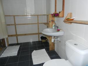 a bathroom with a white toilet and a sink at Amka House in Jambiani