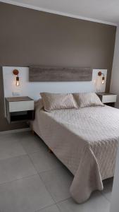 a bedroom with a large bed and two night stands at Jazmin de Lluvia in Vistalba