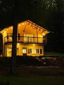 a large house with lights on it at night at Cozy, Lake Lanier property with amazing views in Dawsonville