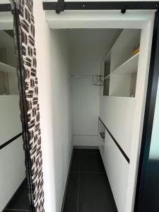 a small room with white walls and black flooring at 2 accomodations -Studio du Manoir -Le Manoir in Punaauia