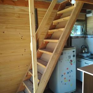 uma escada de madeira numa cozinha com um frigorífico em Casita con vista al mar em Salinas