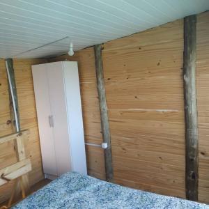 a room with a wooden wall with a closet and a bed at Cabaña con vista al mar in Salinas 