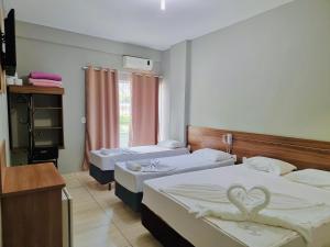 a bedroom with two beds with a heart on them at MAPP Hotel Aparecida-SP in Aparecida