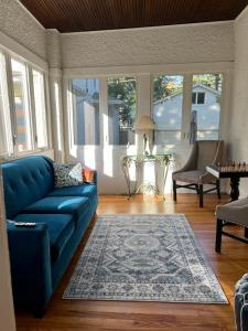 um sofá azul numa sala de estar com janelas em Historic Oakpark Home 