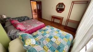 a bedroom with two beds and a quilt at Departamento Puyo Adventure in Puyo