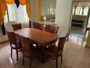 a dining room with a wooden table and chairs at Departamento Puyo Adventure in Puyo