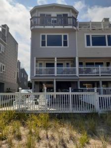 a large house with a white fence in front of it at Modern 4bdr Oceanfront home in Virginia Beach