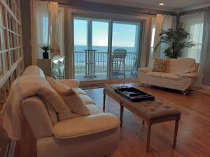 a living room with two couches and a coffee table at Modern 4bdr Oceanfront home in Virginia Beach