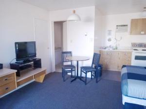 a living room with a table and chairs and a kitchen at Cardston Inn in Cardston