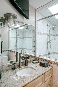 a bathroom with a sink and a large mirror at Modern 4bdr Oceanfront home in Virginia Beach
