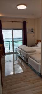 Hotel Eight Fifty في Jagna: سريرين في غرفة مطلة على المحيط