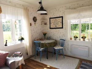 a living room with a table and chairs and windows at Holiday home RAMSJÖ III in Ramsjö