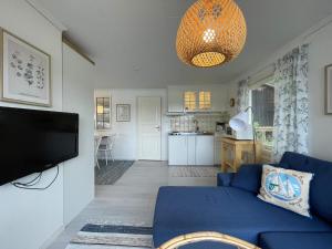 a living room with a blue couch and a kitchen at 4 person holiday home in BENGTSFORS-By Traum in Bengtsfors