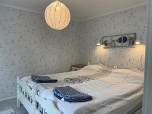 a bedroom with a white bed with two towels on it at Holiday home BENGTSFORS VII in Bengtsfors