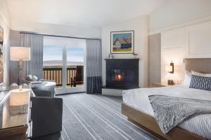 The Lodge at Bodega Bay في بوديغا باي: غرفة فندقية بها سرير وموقد