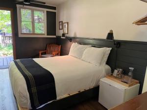 a bedroom with a large white bed and a chair at Highlands Resort in Guerneville