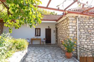 an outside view of a house with a stone wall at Μορχέλα, ολόκληρο σπίτι! in Méga Khoríon