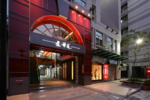 a building with a red sign on the side of it at In One City Inn in Taichung