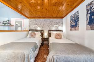two beds in a room with wooden ceilings at Bungalow Canarios 1 ,Arguineguín in Arguineguín +19 photos