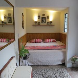 een slaapkamer met een bed en een spiegel bij Balneario Hostal El Pacha in Líbano
