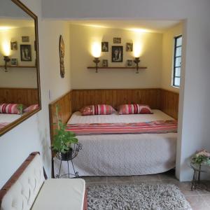ein Schlafzimmer mit einem Bett und einem Spiegel in der Unterkunft Balneario Hostal El Pacha in Líbano