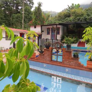 ein Resort mit Pool und Haus in der Unterkunft Balneario Hostal El Pacha in Líbano