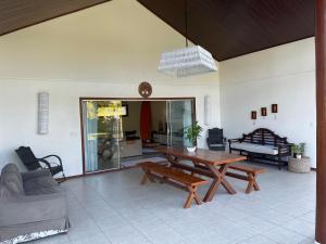 a living room with a wooden table and a couch at Casa Asa Delta - Pipa Natureza in Pipa