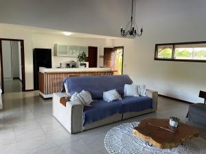 a living room with a blue couch and a kitchen at Casa Asa Delta - Pipa Natureza in Pipa
