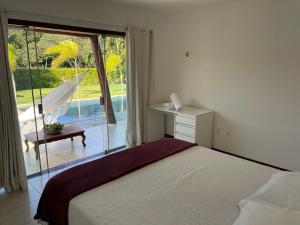 Casa Asa Delta - Pipa Natureza في بيبا: غرفة نوم بسرير ونافذة كبيرة