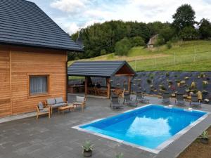 una casa y un patio con piscina y sillas en Comfortable holiday home with a swimming pool for 12 people en Iwierzyce