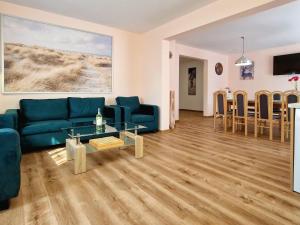 a living room with a blue couch and a table at Comfortable holiday home with a swimming pool for 12 people in Iwierzyce