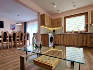 a kitchen and dining room with a glass table at Comfortable holiday home with a swimming pool for 12 people in Iwierzyce