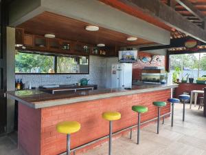 uma cozinha com um bar com bancos em frente em Apartamento Bangalo Cabo Frio em Cabo Frio