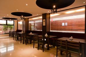 a dining room with tables and chairs in a restaurant at East Town 26 Hotel in Hualien City