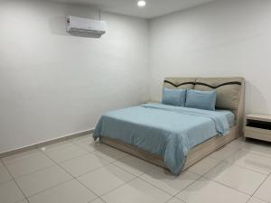 um quarto com uma cama com lençóis azuis e um aquecedor em 4 bedrooms (private bathroom) Perdana Hill Villa em Lahad Datu