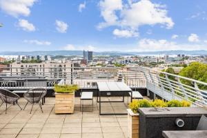a balcony with tables chairs and a view of a city at Beautiful home in the heart of Oslo (Grünerløkka) in Oslo