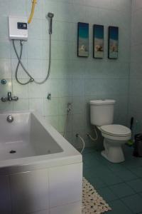 a bathroom with a toilet and a sink and a tub at Baan Sawainam in Koh Tao