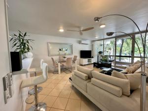 un salon avec un canapé et une table dans l'établissement Noosa Luxury Apartment, à Noosa Heads