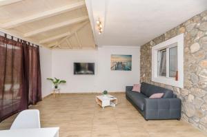 a living room with a blue couch and a stone wall at House Hacienda in Tribunj