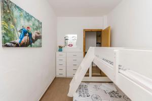 a bedroom with a white bunk bed and a painting at House Hacienda in Tribunj