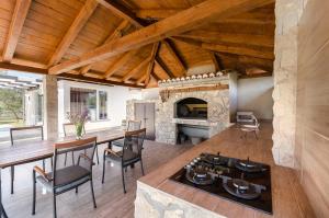 a living room with a stone fireplace and wooden ceilings at House Hacienda in Tribunj