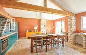 - une cuisine aux murs orange avec une table et des chaises dans l'établissement Stunning Home In St Paul De Vence, à Saint-Paul-de-Vence