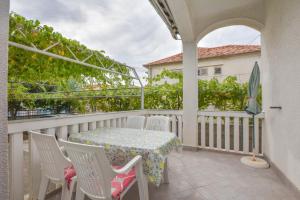 a patio with a table and chairs on a balcony at Apartments Promina in Biograd na Moru